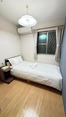 a bedroom with a white bed in a room at \u6771\u4eac\u89b3\u5149\u62e0\u70b9 \u30b9\u30ab\u30a4\u30c4\u30ea\u30fc\u773a\u671b \u5c4b\u4e0a\u4ed8\u4e00\u8ed2\u5bb6 \u6700\u592710\u540d \u3086\u3046\u308f\u4ead in Tokyo
