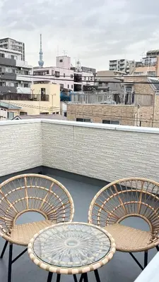 a patio with two chairs and a table on a roof at \u6771\u4eac\u89b3\u5149\u62e0\u70b9 \u30b9\u30ab\u30a4\u30c4\u30ea\u30fc\u773a\u671b \u5c4b\u4e0a\u4ed8\u4e00\u8ed2\u5bb6 \u6700\u592710\u540d \u3086\u3046\u308f\u4ead in Tokyo