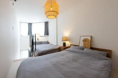 a bedroom with two beds and a chandelier at Hotel Yoyogi Uehara Tokyo in Tokyo