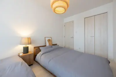 a white bedroom with two beds and a lamp at Hotel Yoyogi Uehara Tokyo in Tokyo