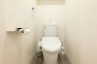 a white toilet in a bathroom with a roll of toilet paper at Hotel Yoyogi Uehara Tokyo in Tokyo