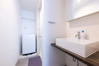 a white bathroom with a sink and a refrigerator at Hotel Yoyogi Uehara Tokyo in Tokyo