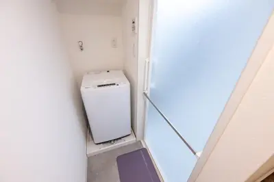 a small white washer and dryer in a room at Hotel Yoyogi Uehara Tokyo in Tokyo
