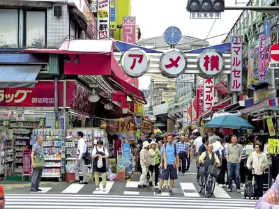 a crowd of people crossing a busy street in a city at rot\u6771\u4e0a\u91ce3\u4e01\u76ee301 in Tokyo