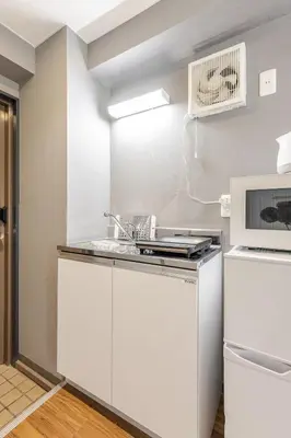 a white kitchen with a sink and a microwave at rot\u6771\u4e0a\u91ce3\u4e01\u76ee301 in Tokyo