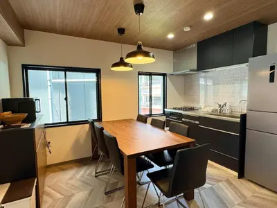 a kitchen with a wooden table and chairs in it at 3 Toilets 2 Showers Renovated Shinjuku Large Family Home in Tokyo