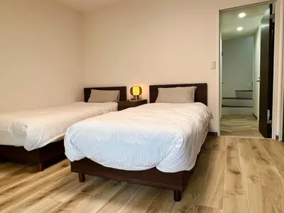 a bedroom with two beds and a mirror at 3 Toilets 2 Showers Renovated Shinjuku Large Family Home in Tokyo