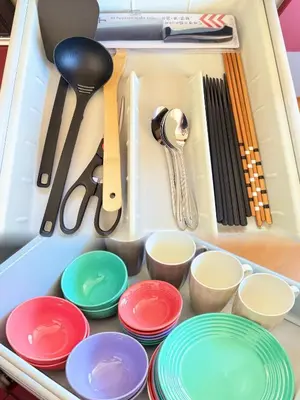 a drawer filled with colorful plates and utensils at Mokuga apartment in Tokyo