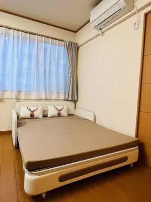 a hospital bed in a room with a window at Mokuga apartment in Tokyo