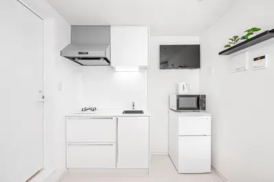 a white kitchen with a sink and a microwave at Subway Higashi Shinjuku Station by 5 mins walk Designer's Apart ment in Tokyo