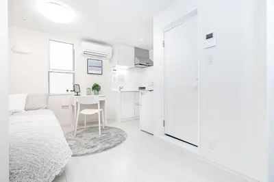 a white bedroom with a bed and a desk at Subway Higashi Shinjuku Station by 5 mins walk Designer's Apart ment in Tokyo
