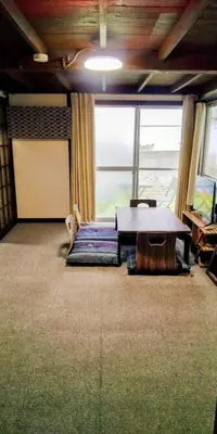a living room with a table and a large window at \u6771\u65b0\u5c0f\u5ca95\u4e01\u76ee in Tokyo