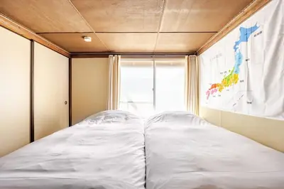 a large bed in a room with a window at \u6771\u65b0\u5c0f\u5ca95\u4e01\u76ee in Tokyo