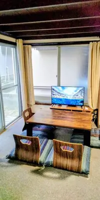 a laptop computer sitting on top of a wooden table at \u6771\u65b0\u5c0f\u5ca95\u4e01\u76ee in Tokyo