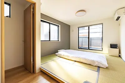 a bedroom with a bed and two windows at JR yamanote line ikebukuro in Tokyo