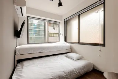 two beds in a room with two windows at rot\u6771\u4e0a\u91ce3\u4e01\u76ee302 in Tokyo
