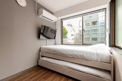 a bedroom with a bed and a large window at rot\u6771\u4e0a\u91ce3\u4e01\u76ee302 in Tokyo
