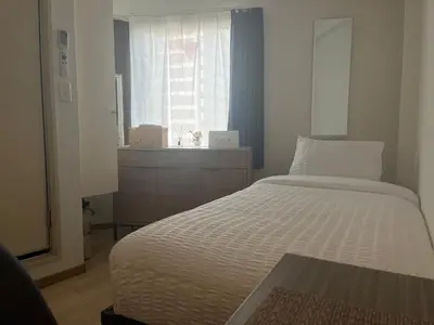 a small bedroom with a bed and a window at CraftFlat Komagome 501 a compact studio at excellent location in Tokyo