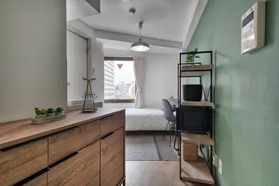 a bedroom with a bed and a desk with a television at CraftFlat Komagome 501 a compact studio at excellent location in Tokyo