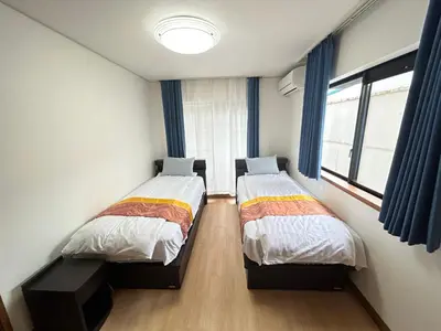 two twin beds in a room with a window at Near Asakusa, 5-min from Station, 5BR 150 square meters House, Near Skytree in Tokyo