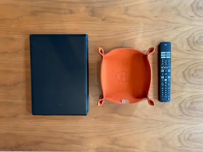 an orange pillow next to a book and a remote control at and CITY\u4e09\u8ed2\u8336\u5c4b in Tokyo