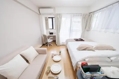 a small bedroom with two beds and a couch at Sakura Serenity House Komagome in Tokyo