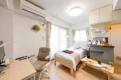 a bedroom with a bed and a desk and a kitchen at Sakura Serenity House Komagome in Tokyo