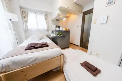 a bedroom with two beds and a desk at Sakura Serenity House Komagome in Tokyo