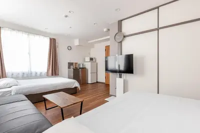 a hotel room with two beds and a flat screen tv at rot\u6771\u4e0a\u91ce3\u4e01\u76ee401 in Tokyo