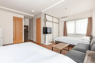 a bedroom with two beds and a couch and a tv at rot\u6771\u4e0a\u91ce3\u4e01\u76ee401 in Tokyo