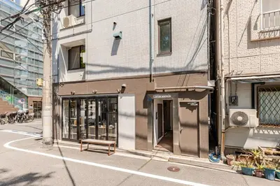 a bench sitting outside of a building on a street at rot\u6771\u4e0a\u91ce3\u4e01\u76ee401 in Tokyo