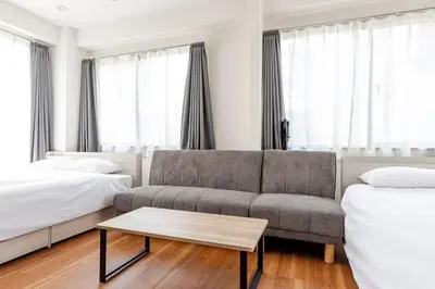 a living room with a couch and two beds at rot\u6771\u4e0a\u91ce3\u4e01\u76ee501 in Tokyo