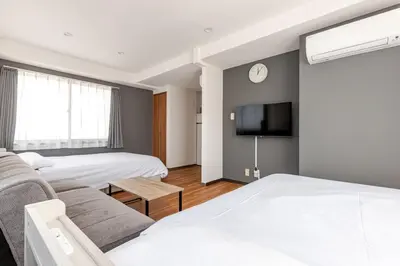 a hotel room with two beds and a tv at rot\u6771\u4e0a\u91ce3\u4e01\u76ee501 in Tokyo