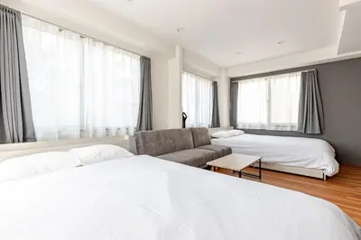 a hotel room with two beds and a couch at rot\u6771\u4e0a\u91ce3\u4e01\u76ee501 in Tokyo