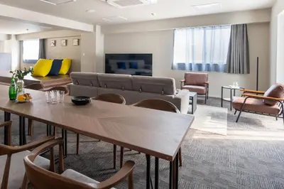 a living room with a couch and a table and chairs at \u5c0f\u6edd\u6a4b\u30d1\u30b7\u30d5\u30a3\u30ab\u30d3\u30eb in Tokyo