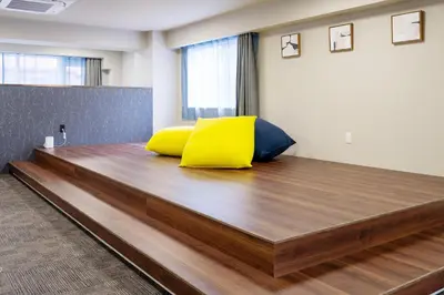 a bed with yellow and blue pillows in a room at \u5c0f\u6edd\u6a4b\u30d1\u30b7\u30d5\u30a3\u30ab\u30d3\u30eb in Tokyo