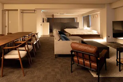 a living room with a bed and a couch and chairs at \u5c0f\u6edd\u6a4b\u30d1\u30b7\u30d5\u30a3\u30ab\u30d3\u30eb in Tokyo