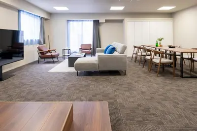 a living room with a couch and a table and chairs at \u5c0f\u6edd\u6a4b\u30d1\u30b7\u30d5\u30a3\u30ab\u30d3\u30eb in Tokyo