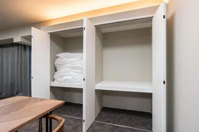 a small closet with white shelves in a room at \u5c0f\u6edd\u6a4b\u30d1\u30b7\u30d5\u30a3\u30ab\u30d3\u30eb in Tokyo