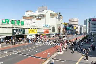 a crowd of people crossing a busy city street at \u5c0f\u6edd\u6a4b\u30d1\u30b7\u30d5\u30a3\u30ab\u30d3\u30eb in Tokyo