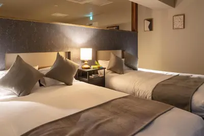 a hotel room with two beds and a table with a lamp at \u5c0f\u6edd\u6a4b\u30d1\u30b7\u30d5\u30a3\u30ab\u30d3\u30eb in Tokyo