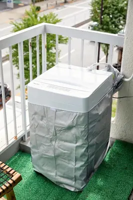 a large green trash can sitting on a porch at \u4e80\u4e43\u5eb5Kamenoan in Tokyo