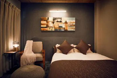 a hotel room with a bed and a chair at \u4e80\u4e43\u5eb5Kamenoan in Tokyo