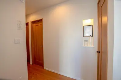 a hallway with a white wall and a door at \u6c60\u888b\u672c\u753a201 in Tokyo