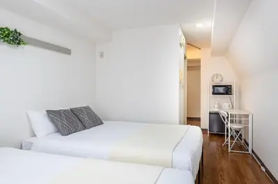 a bedroom with two beds and a desk at \u30a2\u30b9\u30d4\u30a2503 in Tokyo