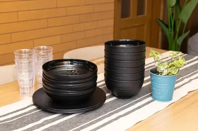 three black plates and a potted plant on a table at Villa Jujo in Tokyo