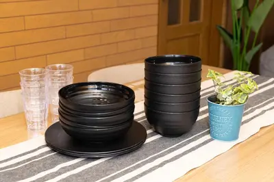 three black plates and a potted plant on a table at Villa Jujo in Tokyo