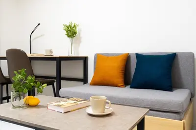 a living room with a couch with orange and blue pillows at \u30aa\u30fc\u30af\u30d6\u30e9\u30f3\u30ab\u5e61\u30f6\u8c37 in Tokyo