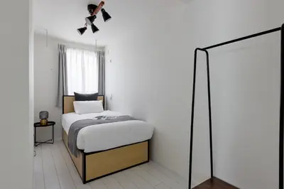 a small bedroom with a bed and a mirror at \u30aa\u30fc\u30af\u30d6\u30e9\u30f3\u30ab\u5e61\u30f6\u8c37 in Tokyo