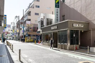 a woman walking down a street in a city at \u30aa\u30fc\u30af\u30d6\u30e9\u30f3\u30ab\u5e61\u30f6\u8c37 in Tokyo